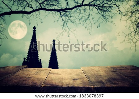 Halloween Holiday concept. Empty rustic table in front of scary night sky, forest and full moon background. Ready for product display montage