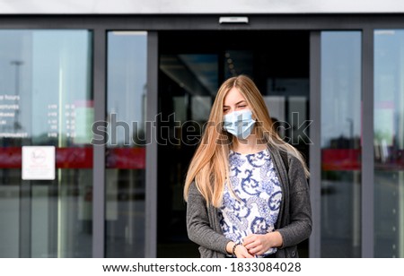Young beautiful girl goes out store with face mask.USA. High quality photo