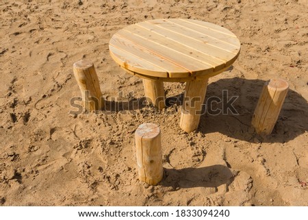 Table and chairs made of wooden bars and boards on the sand. A place to relax on the beach