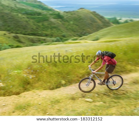 Boys rides a bike in Macin mountains, Tulcea, Romania.