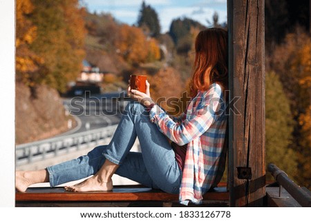 Girl with a cup of coffee. picture taken through window glass. morning at dawn
