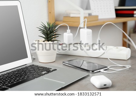 Smartphone charging with cable on light stone table Royalty-Free Stock Photo #1833132571