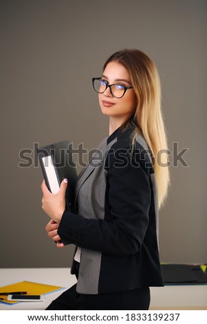 young beauty in the office and jacket holding documents