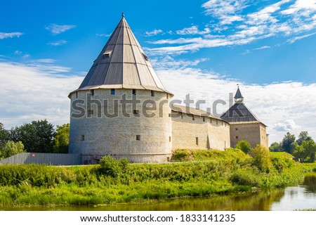Aerial panoramic view of famous medieval fortress in Staraya Ladoga at sunset. Ancient Russian historical fort on Volkhov River on a sunny summer day. Europe, Russia, Leningrad region, St. Petersburg. Royalty-Free Stock Photo #1833141235
