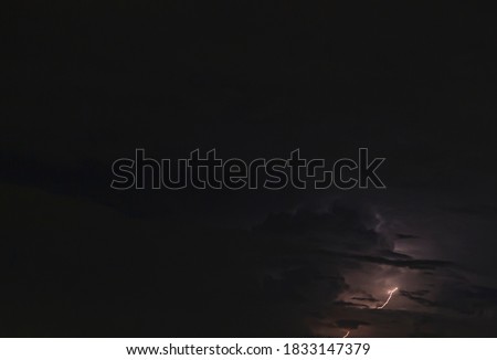 Picture of a flash in the night sky with glowing clouds in summer