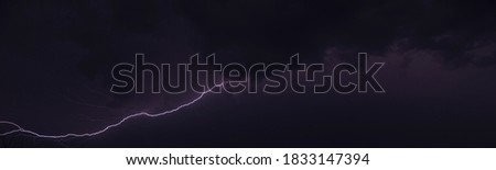 Picture of a flash in the night sky with glowing clouds in summer