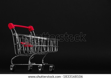 Shopping cart on a black background, blank for the design, concept. Copy space.