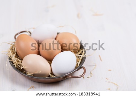 Fresh eggs in a bowl on a white background.