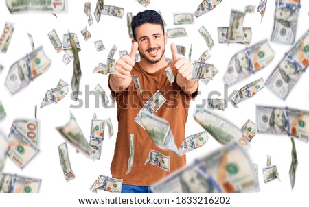 Young hispanic man wearing casual clothes approving doing positive gesture with hand, thumbs up smiling and happy for success. winner gesture.