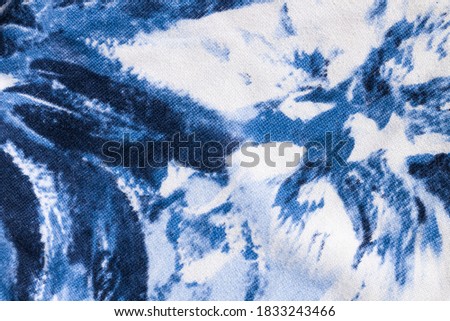 Tie-dye cotton fabric texture blue and white paint colors. Ancient resist-dyeing textile coloring technique, saturated primary colors, bold patterns, simple motifs, monochromatic color schemes garment