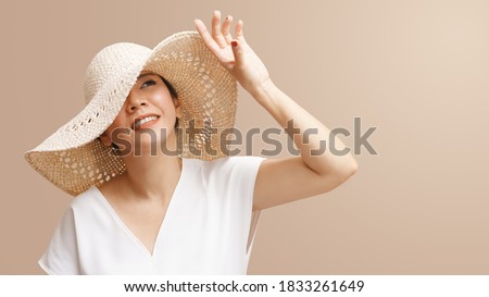 Portrait of beautiful young asian woman wearing straw hat wide brim to protect her flawless face from ultraviolet in the sunlight. Facial Sunscreens, SPF, Sunspots, Treatments, Skin care products. Royalty-Free Stock Photo #1833261649