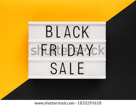 Stock photo of Black Friday sale text on a white light box and a bicolor background