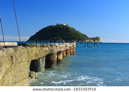 Gallinara Island with blue sky and
a concrete walkway