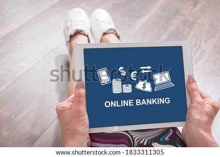 Woman sitting on the floor with a tablet showing online banking concept