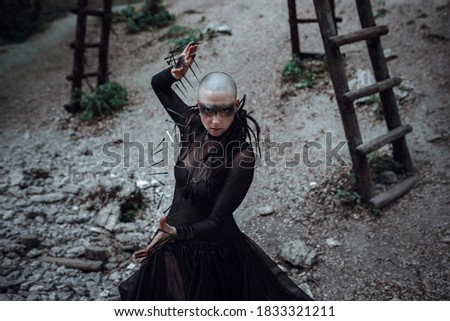 Beautiful young bald woman portrait outdoors. spiritual concept. Witch in black. Makeup and character for Halloween.
