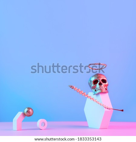 Golden skull with halo and geometric shapes on a pink blue background, Halloween concept