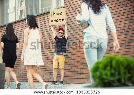 I have a voice. Dude with sign - man stands protesting things that annoy him. Solo demonstration his right to talk free on the street with sign. Opinion heard by public. Social life, politics Royalty-Free Stock Photo #1833355726