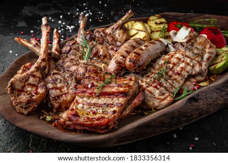 Different types of cooked meat, beef, rack of lamb and grilled pork, chicken and turkey baked in sauce, sausages with vegetables Royalty-Free Stock Photo #1833356314