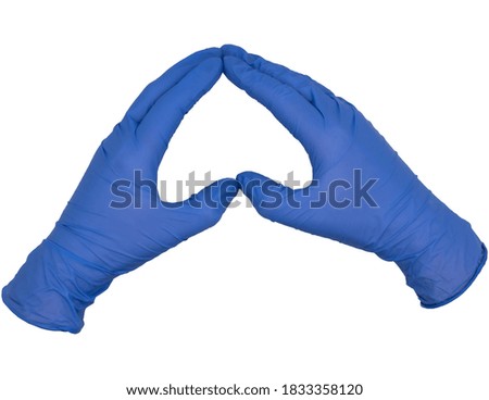 Isolated hands wearing blue nitrile examination gloves, making a heart or love shape frame between thumb and index finger with fingers together. Female hand
