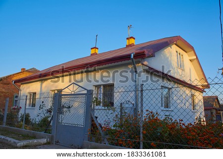 house in autumn with flowers,house at sunset in autumn with autumn flowers