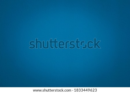 Beautiful Abstract Grunge Decorative Navy Blue Wall Background. Image of the dark colored concrete wall has light from the center of the picture. There is space for designing and text.