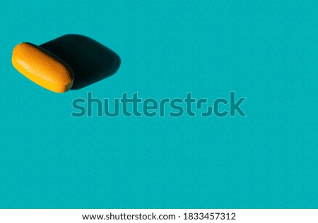 One orange pill on the textured background