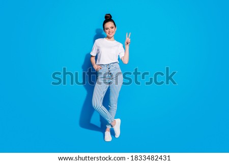Full length body size view of her she nice-looking attractive lovely pretty cheerful cheery teen girl showing v-sign posing leisure isolated over bright vivid sine vibrant blue color background