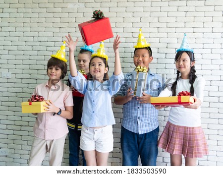 Group of Cheerful Diverse children holding gift box in party. various nationalities children's party theme studio