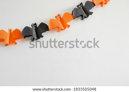Halloween background white wall with garland in bat shape