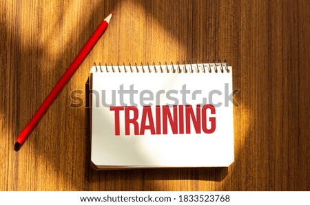 Red pen and notepad with text TRAINING in the white background