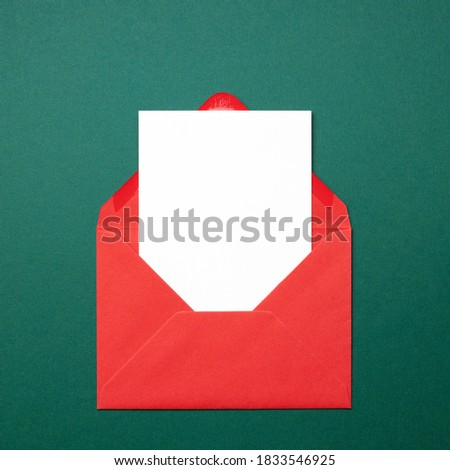 Mock-up with empty card in red envelope on green background. Christmas greeting card.