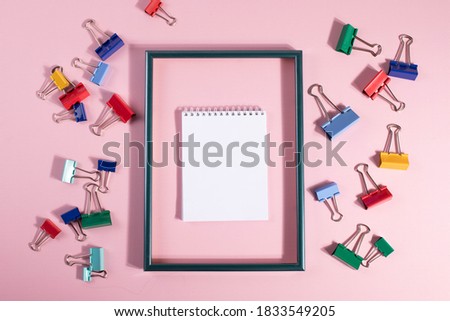 colourful metal paper clips and empty frame. minimalism style. 