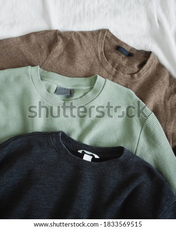 Pile of woman's earth toned jumpers. Flat lay. Top view	 Royalty-Free Stock Photo #1833569515