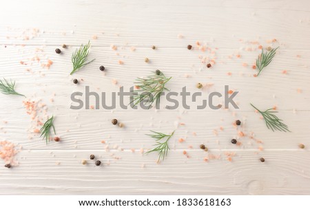 Background with dill leaves, pink salt and pepper on a white wooden background with space for text. View from above. Template. Royalty-Free Stock Photo #1833618163