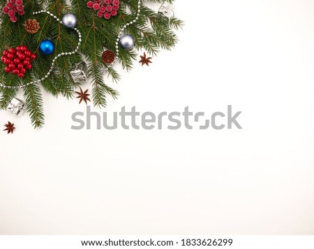 Christmas background - spruce branches are on a white background decorated with Christmas toys.Space for text.