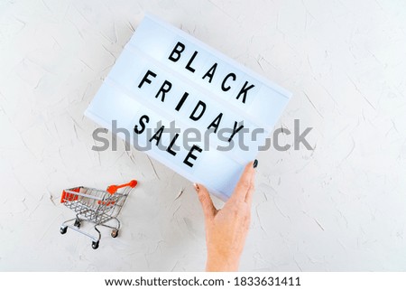 Top view of hands, black friday promotion sale words on lightbox, gift boxes, laptop , shopping cart and bag, credit bank card on table. Online shopping, Sale, e-shopping, ordering, payment.concept.