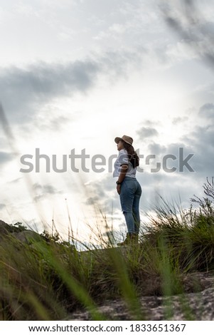 Young woman admiring the landscape with a cloudy sky in background