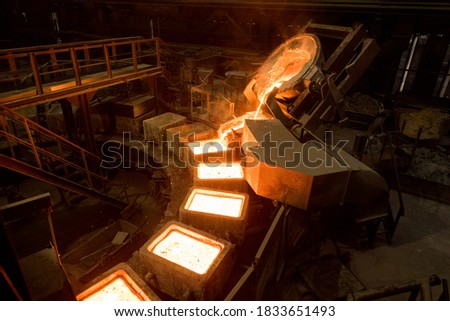 Tank pours liquid metal in the molds by carousel machine Royalty-Free Stock Photo #1833651493