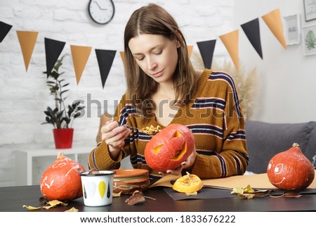 Young woman making Halloween decorations at home. Autumn season DIY craft.