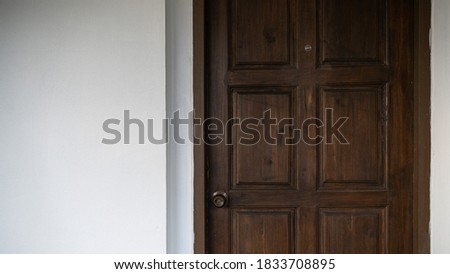 Image of wooden hotel door with white wall background.