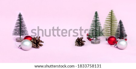 Christmas tree, red toys on pink background in minimal style. Decorative Christmas ornaments, new year and winter concept, banner, copy space