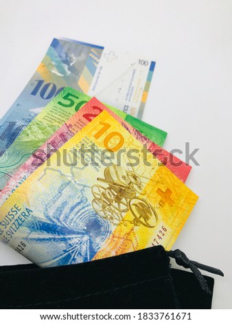 Money; Swiss franc banknote inside pouch bag on white background.- accounting, finance, business and budget concept.