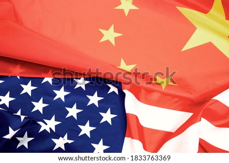 Flag of the United States with China on a waving cotton texture background. Concept of political relationships and conflicts.