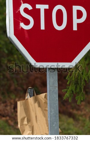 A large stop sign with a paper bag hooked on a post.