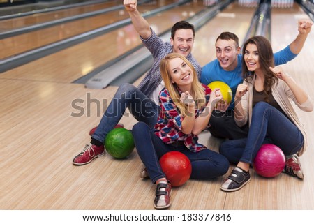 Young group of friends in bowling alley  