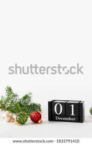 1 December calendar with Christmas balls decoration on white background, preparation for holiday, Happy New Year and Xmas, hello winter Concept. Copy space for text, vertical.