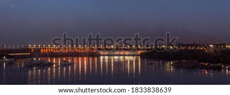 Night view of the illuminated Dnieper hydroelectric station. In photography, light sources have a star rays effect.