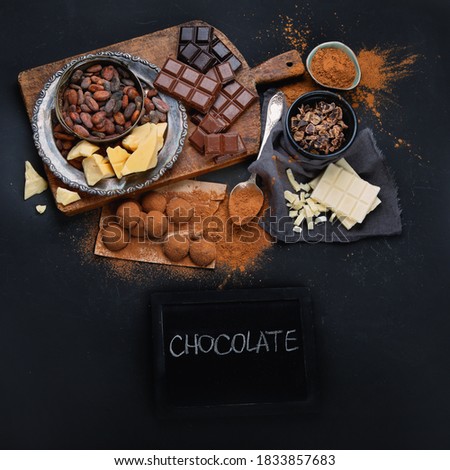 Delicious chocolate bars and pieces. Top view, chalkboard