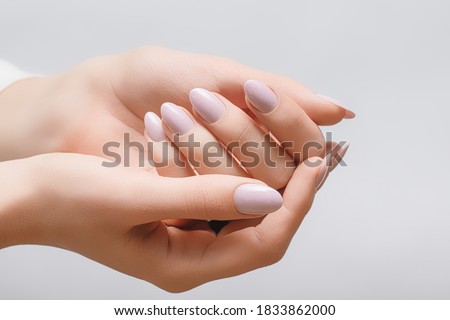 Female hands with rose nail design. Pink glitter nail polish manicure. Woman hands on white background