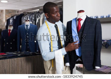 Portrait of afro-american man customer choosing business style tie in the shop. High quality photo
